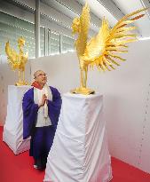 Monk admires golden phoenix statue at Kyoto temple