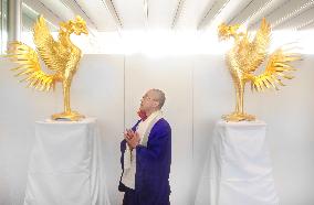 Monk watches golden phoenix statue at Kyoto temple