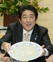 Abe shows off dish of blowfish sashimi