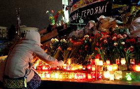Woman lays candle for victims of violence in Kiev