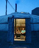 Family stays warm in a Mongolian ger using coal stove