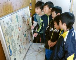 Students gather around Tezuka's drawings