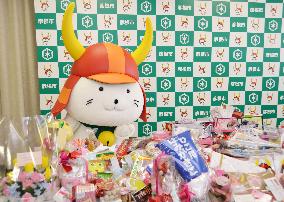 Mascot surrounded by chocolate gifts on St. Valentine's Day
