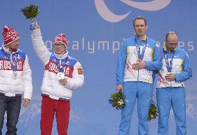 Ukrainian Paralympic gold medalists cover medals on podium