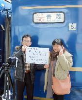 People pose with retired 'Akebono' night train at Aomori Station