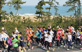 Tottori marathon runners along sand dunes