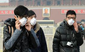 People wear masks at hazy Tiananmen Square