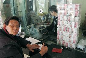 Money stacked at China bank's teller window