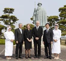 U.S. envoy Kennedy poses before pearl king Mikimoto's statue