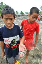Tuvalu kids catch fish left on ground after tide goes out