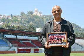 Algerian man holds photo of USM Alger players in 1990s