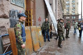 Men in camouflage stand before Kiev city building