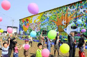 Kids release balloons before "Mural of Hope"