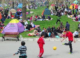 Adults, children relax at park in Tehran