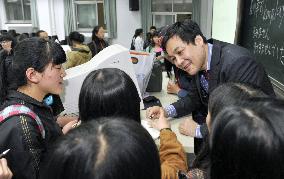 Students surround Japanese teacher for autographs
