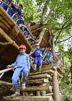 Children visit tree house in open-air class