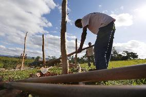 Brazilian peasants work to build shanty house on idle land