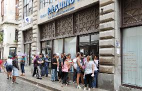 People wait in line before Havana mobile phone shop