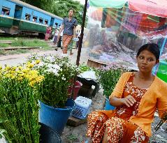Woman sells flowers at railway platform in Yangon