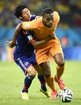 Morishige tries to stop Drogba in Japan-Ivory Coast