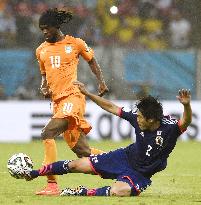 Uchida tackles Gervinho in Japan-Ivory Coast