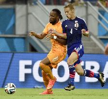 Honda vies for ball against Drogba in Japan-Ivory Coast