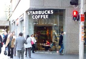 People walk by Starbucks Coffee shop in Sydney