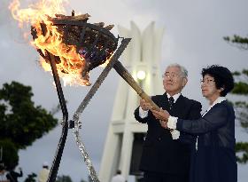 Families of Okinawa victims light fire