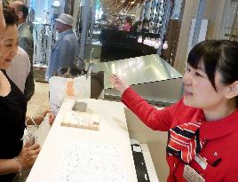 Chinese worker helps foreign shoppers at Ginza Mitsukoshi