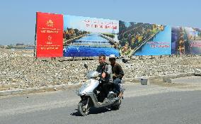 Men ride motorcycle in Hotan, Uyghur region