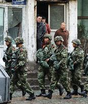 Armed police walk near explosion site in Urumqi