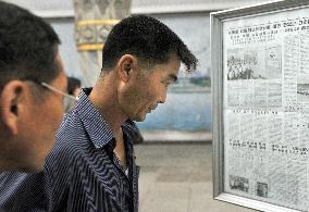 N. Korea citizens read newspaper at subway station