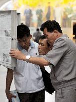 N. Korea citizens read newspaper at subway station