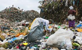 People collect e-waste at dump in Kenya