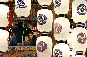 Woman waves through lanterns as Gion Festival begins