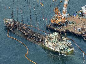 Wreckage of exploded tanker pulled out of water