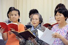 Choral singers practice to restage post-A-bomb service