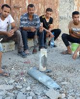 Men sit around a shell in Gaza