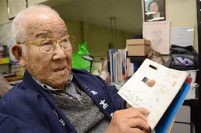 A-bomb victim in Brazil shows old medical notebook