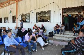 People wait for pass permit near check point in Gaza