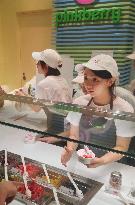 Worker takes order at Pinkberry's 1st outlet in Japan