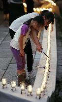 Girls light candle to mourn victims of 1985 JAL plane crash
