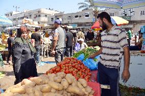 Man sells vegetables in open market in Gaza