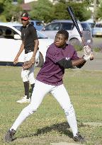 Young African practices baseball batting in Japan