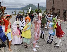 Costume play lovers pose with Lake Toya in background