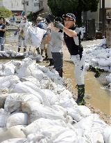 Volunteers carry out mud in mudslide-hit area in Hiroshima