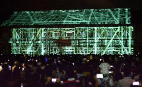 Big crowd watches 3D images of Tomioka Silk Mill on wall