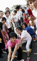Pyongyang children play tug-of-war with pro wrestlers