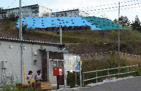 Temporary homes for quake victims stand on reinforced hill