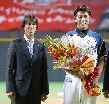 Nippon Ham's Inaba gets flowers from ski jumper Kasai